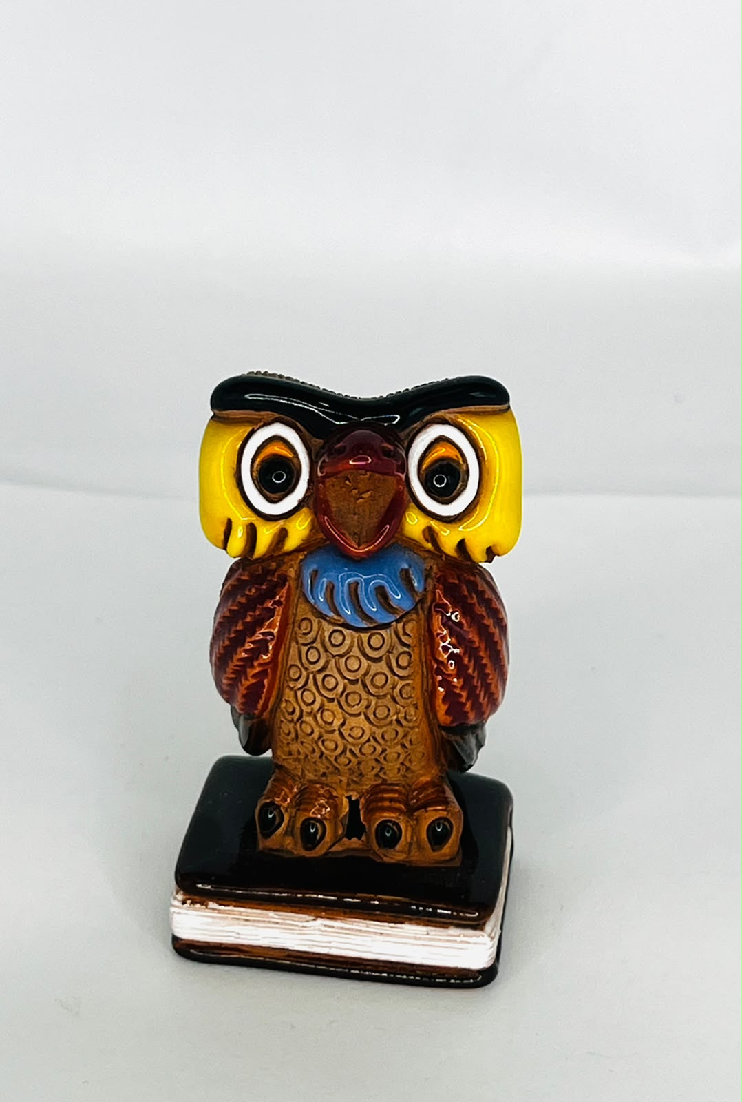 FIGURA DE BÚHO DE LA SABIDURÍA SOBRE LIBRO
